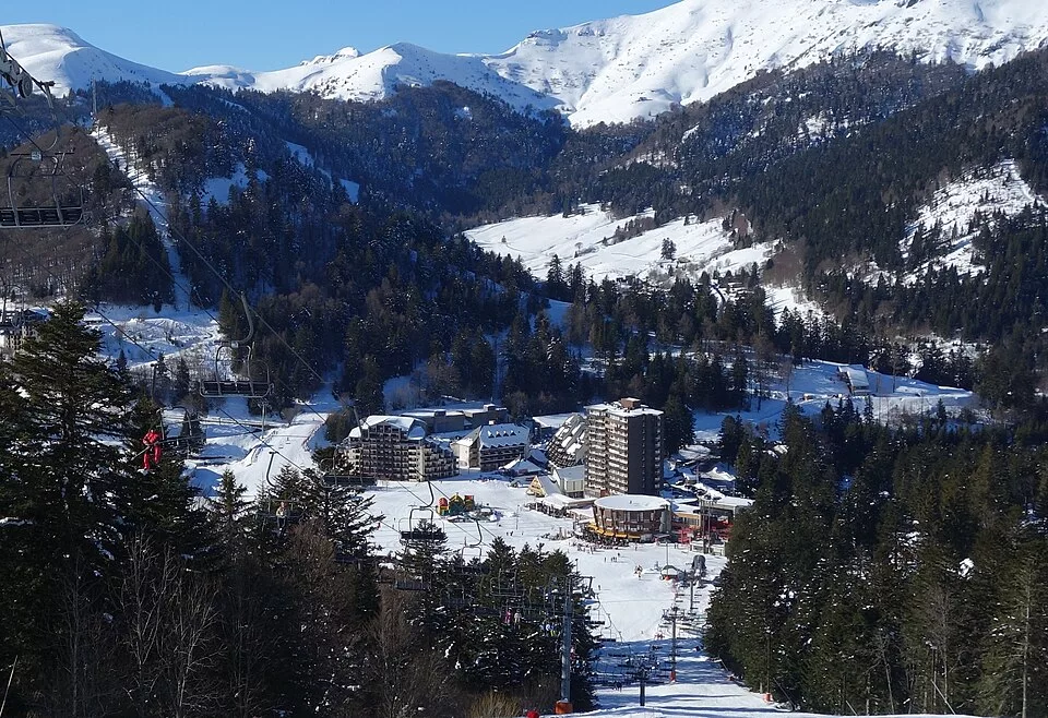 Le Lioran resort under snow, ski runs between the fir trees
