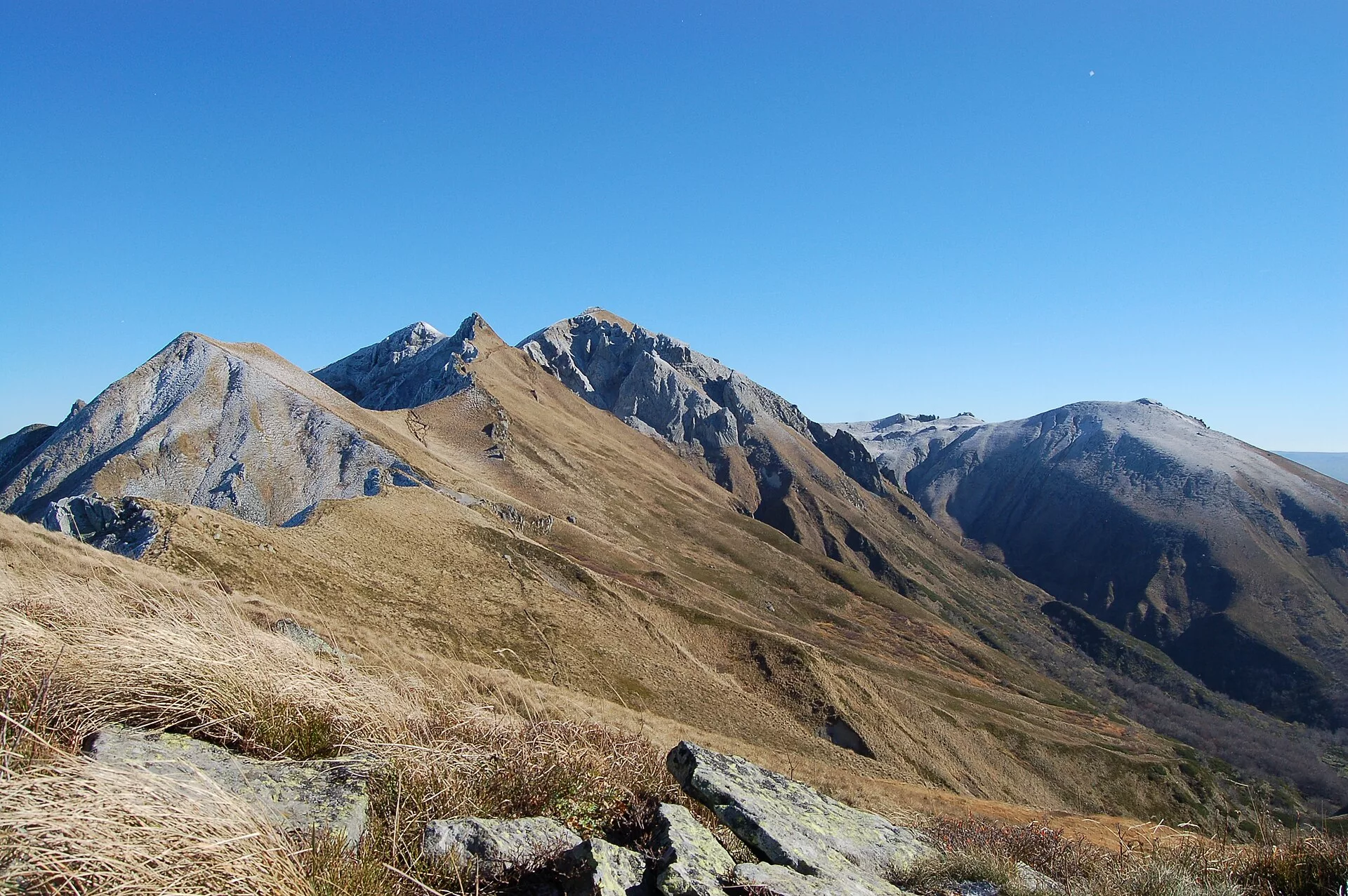 Sentier sinueux menant au puy de Sancy, sous un ciel bleu d'été